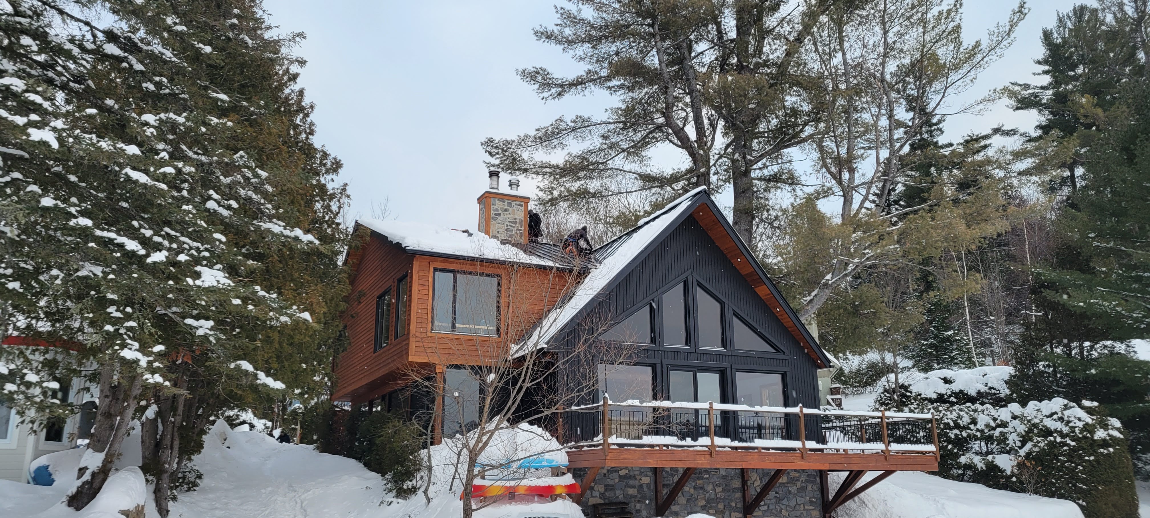 Completed metal roof on an A-frame chalet in winter