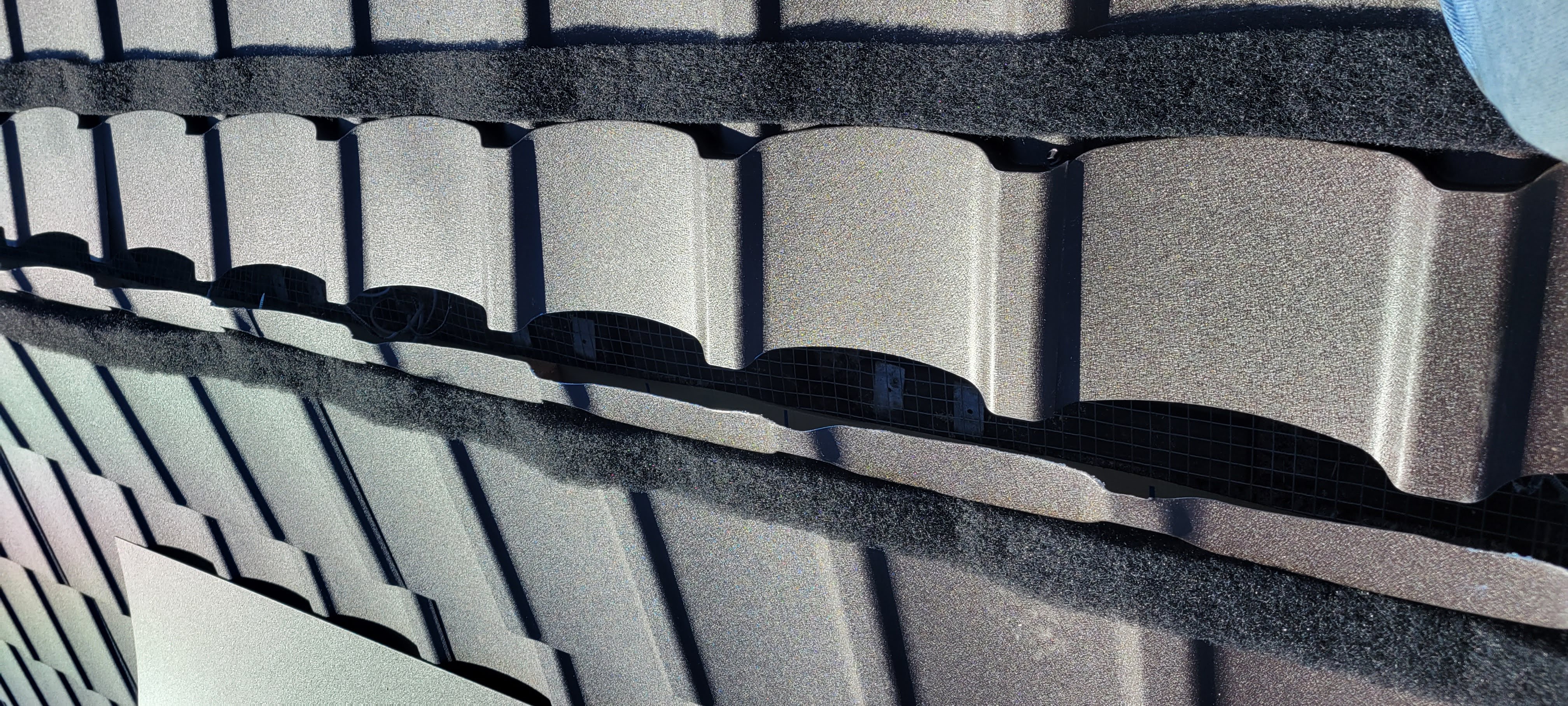 Close-up of metal shingles being installed on a roof